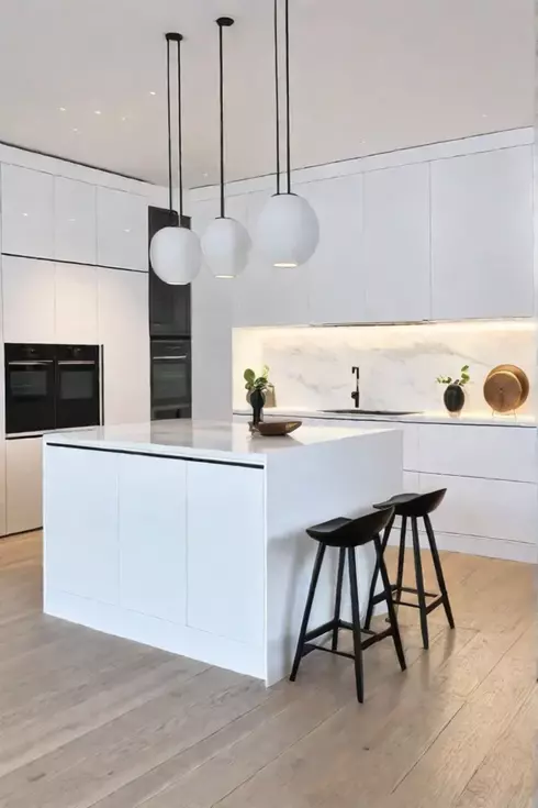 A bright airy kitchen with a simple Scandinavianinfluenced island that features a