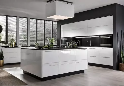 A modern kitchen with sleek white cabinets and a spacious island featuringfeat